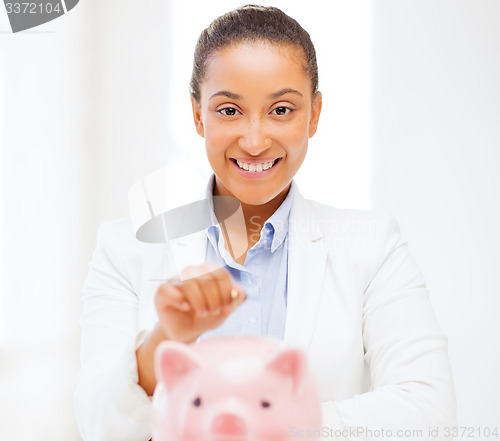 Image of woman with piggy bank and coin