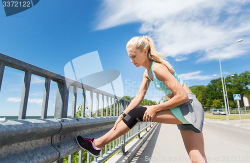 Image of young woman with injured knee or leg outdoors