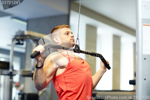 Image of man flexing muscles on cable machine gym