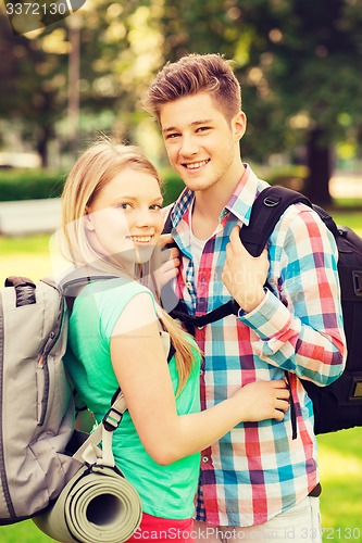 Image of smiling couple with backpacks in nature