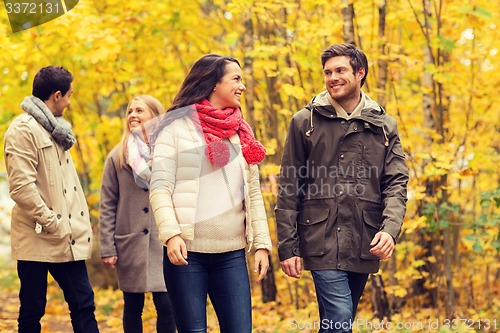 Image of group of smiling men and women in autumn park