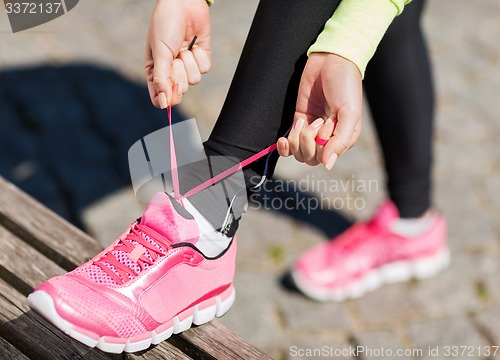 Image of runner woman lacing trainers shoes