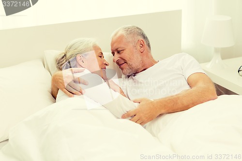 Image of happy senior coupler lying in bad at home