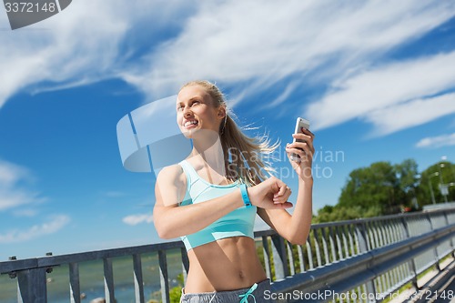 Image of happy woman with heart rate watch and smartphone