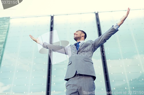 Image of young smiling businessman over office building