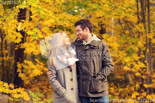 Image of smiling couple hugging in autumn park