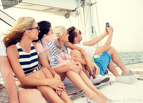 Image of smiling friends sitting on yacht deck