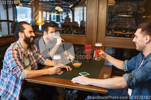 Image of happy male friends drinking beer at bar or pub