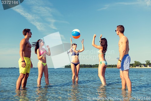 Image of smiling friends in sunglasses on summer beach