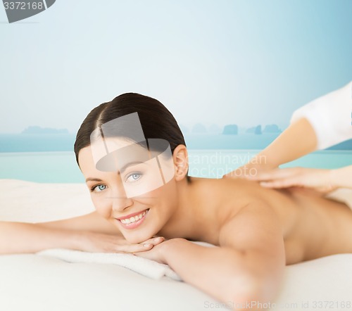 Image of happy beautiful woman having back massage