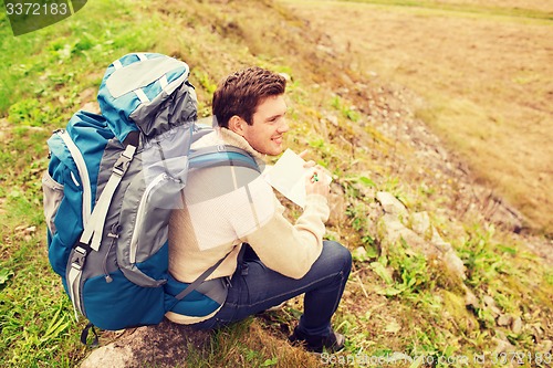 Image of smiling man with backpack hiking