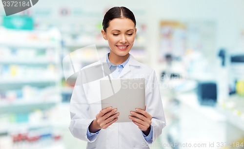 Image of smiling female doctor with tablet pc at drugstore