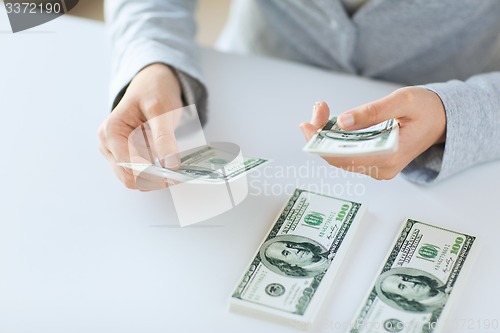 Image of close up of woman hands counting us dollar money