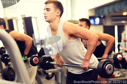 Image of group of men with barbells in gym