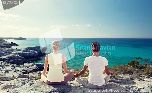 Image of couple making yoga exercises outdoors