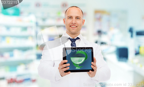 Image of smiling male doctor with tablet pc at drugstore