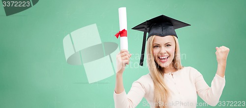 Image of student in trencher cap with diploma over green