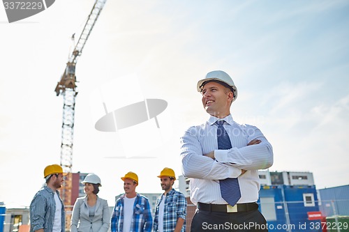 Image of happy builders and architect at construction site