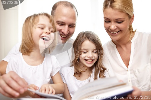 Image of happy family reading book at home