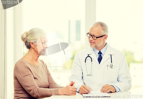 Image of smiling senior woman and doctor meeting