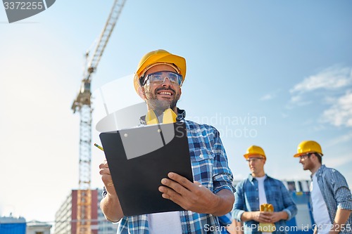 Image of builder in hardhat with clipboard at construction