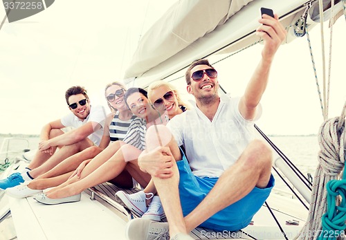 Image of smiling friends sitting on yacht deck