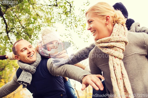Image of happy family having fun in autumn park