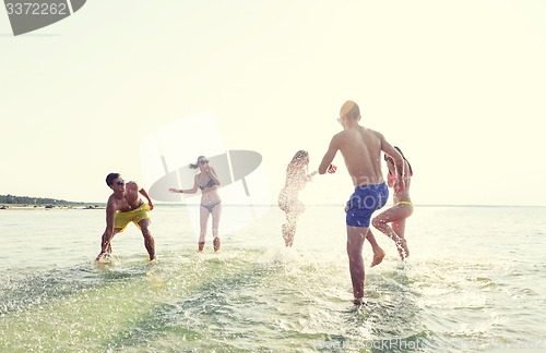 Image of happy friends having fun on summer beach