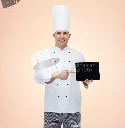 Image of happy male chef cook showing with tablet pc