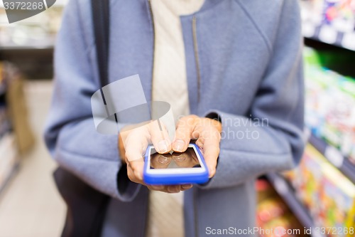 Image of close up of woman with smartphone in market