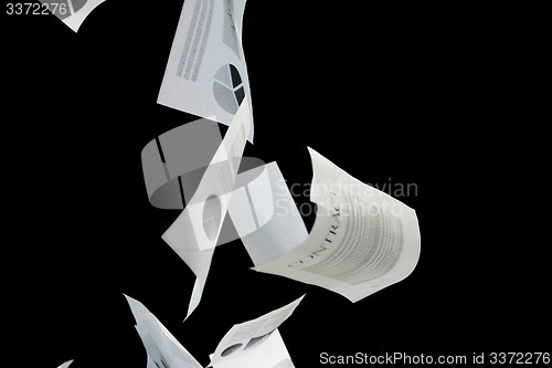 Image of business papers falling down over black background