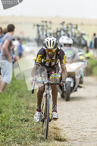 Image of Merhawi Kudus Ghebremedhin Riding on a Cobblestone Road - Tour d