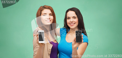 Image of happy student girls showing smartphones screens