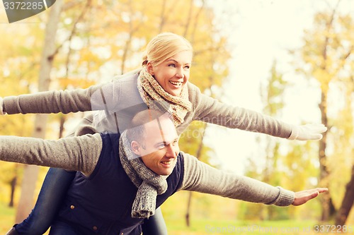 Image of smiling couple having fun in autumn park