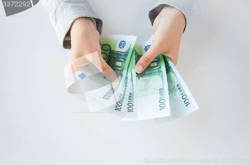 Image of close up of woman hands counting euro money