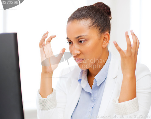 Image of stressed african woman with computer