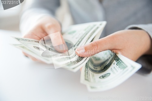 Image of close up of woman hands counting us dollar money