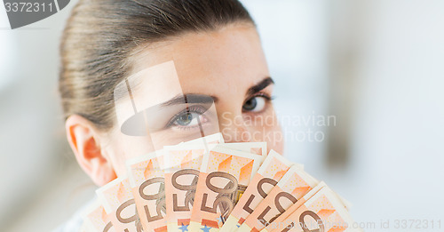 Image of woman hiding her face behind euro money fan