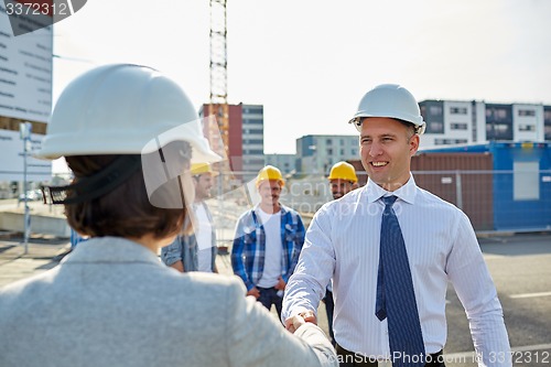 Image of builders making handshake on construction site