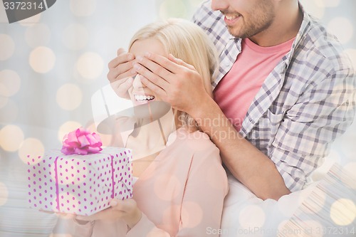 Image of happy man giving woman gift box at home