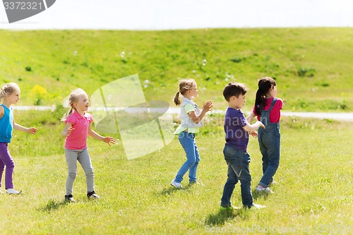 Image of group of kids catching soap bubbles outdoors