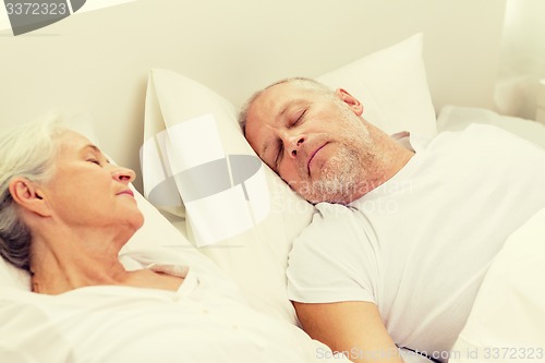Image of happy senior coupler lying in bad at home