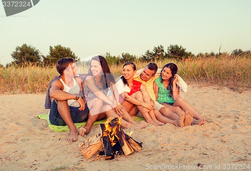 Image of smiling friends in sunglasses on summer beach