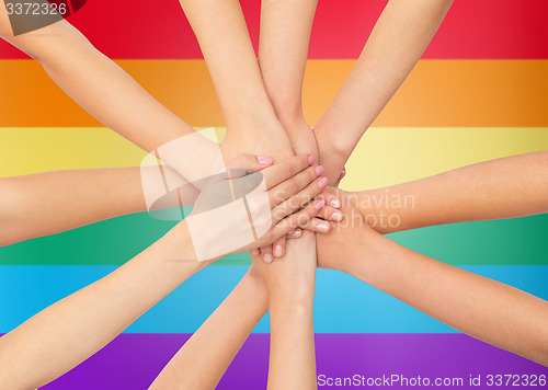 Image of close up of women with hands on top over rainbow