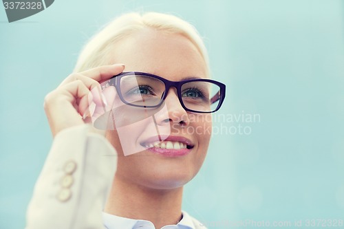 Image of young smiling businesswoman over office building