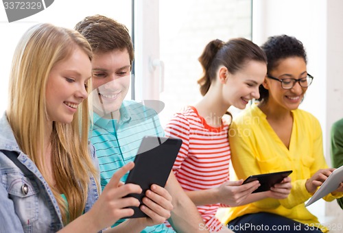 Image of smiling students with tablet pc at school