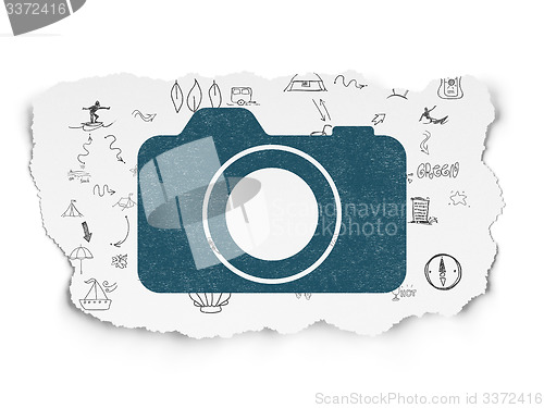 Image of Tourism concept: Photo Camera on Torn Paper background