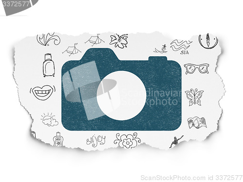Image of Tourism concept: Photo Camera on Torn Paper background
