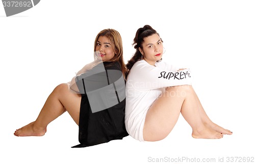 Image of Two woman sitting back to back.