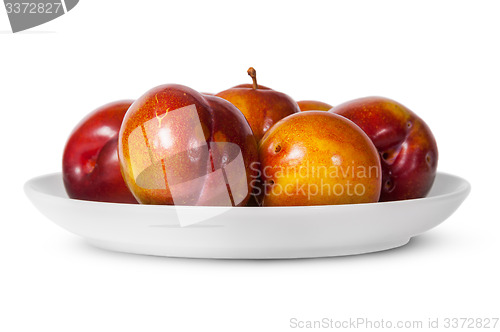 Image of In front red and yellow plums on white plate